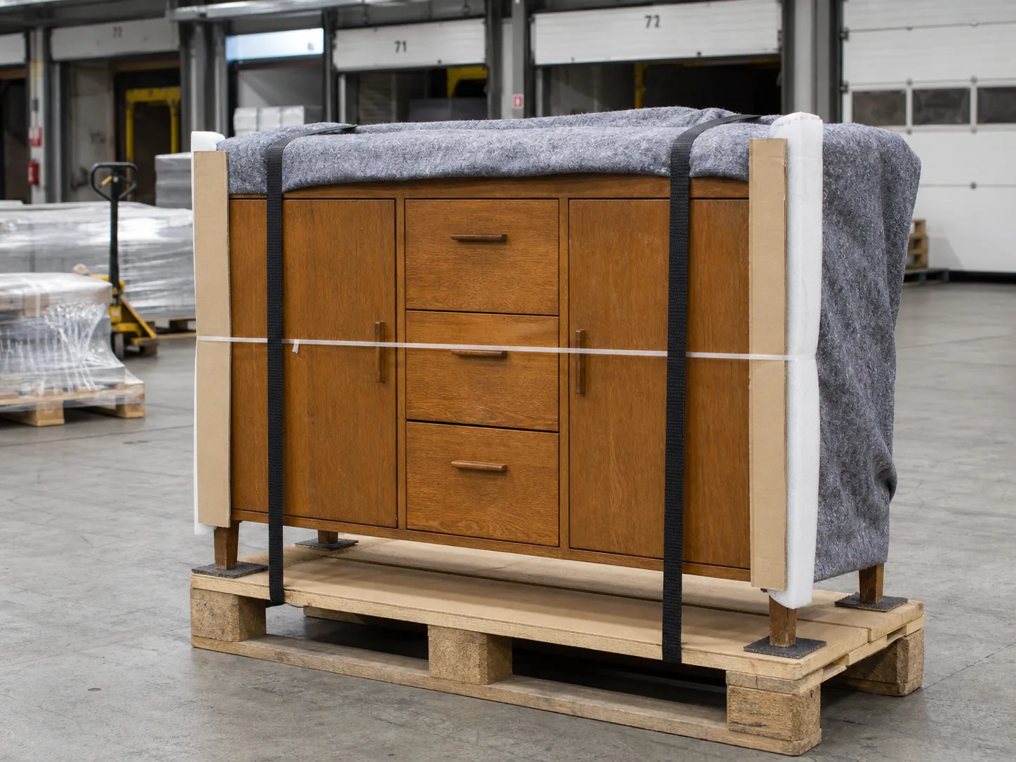 Holz-Sideboard mit Schutzdecke, Kantenschutz und Gurten auf einer Europalette